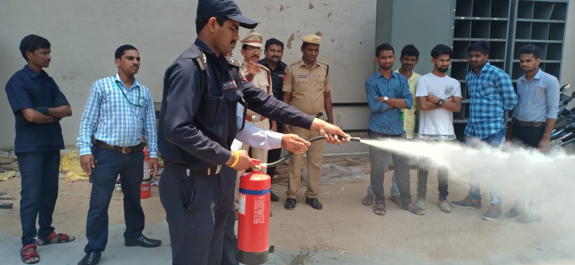 A Falcon Eye guard demonstrating a fire extinguisher during a training drill